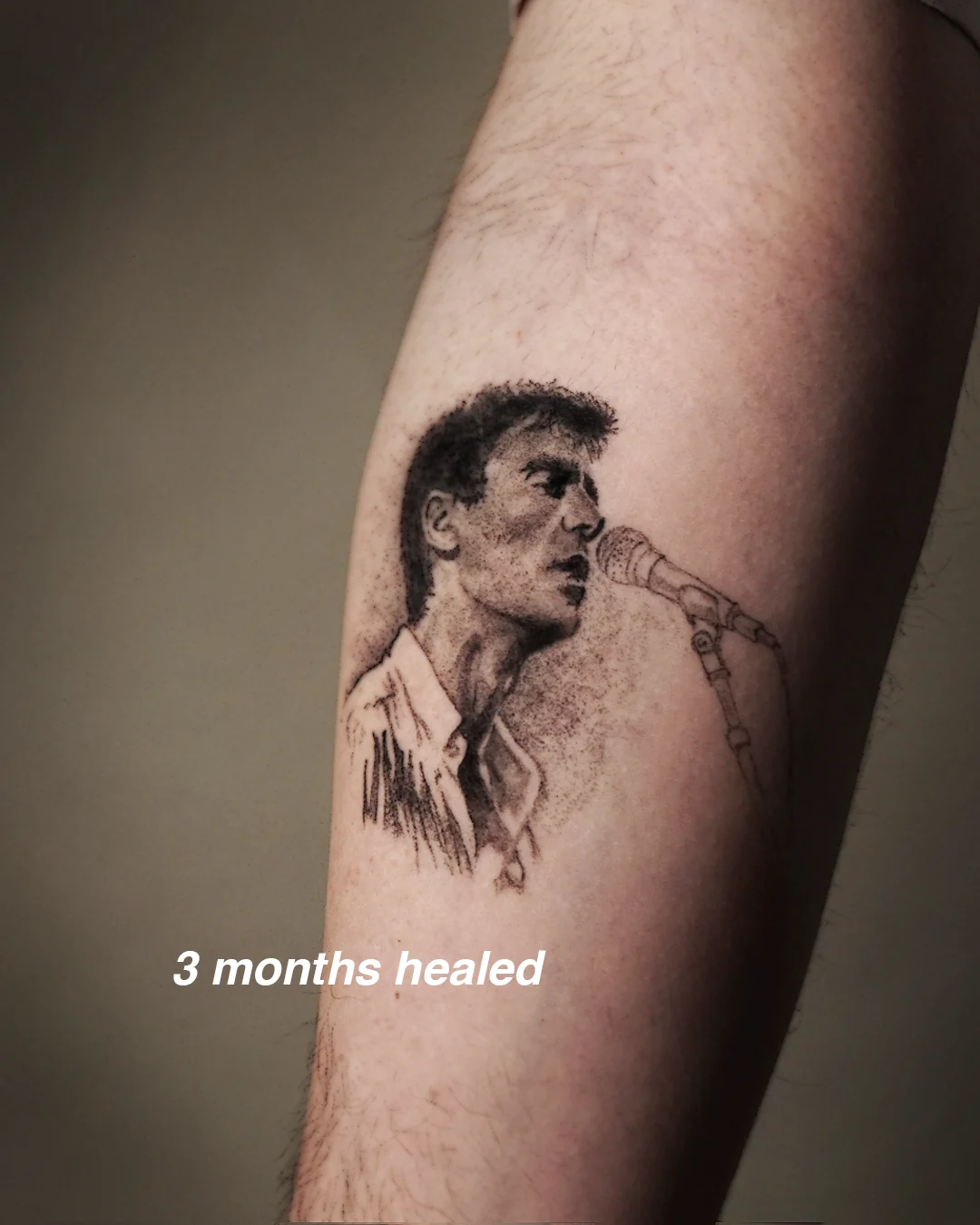 The singer-at-a-microphone micro-realism tattoo, second angle, healed
