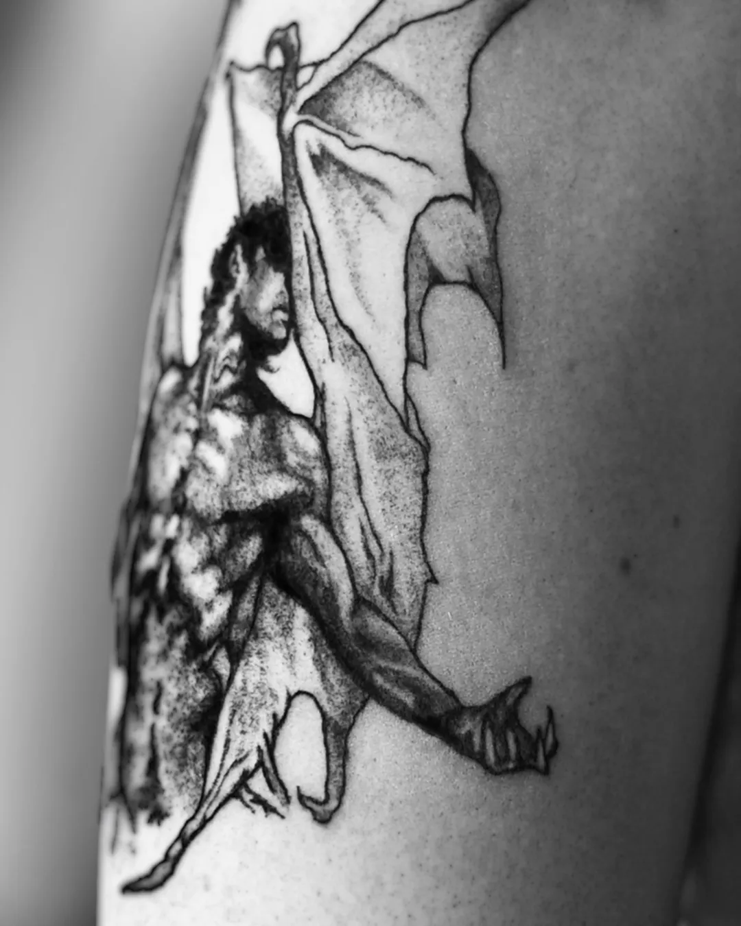 Engraving-style winged demon tattoo rendered in fine dotwork on the arm