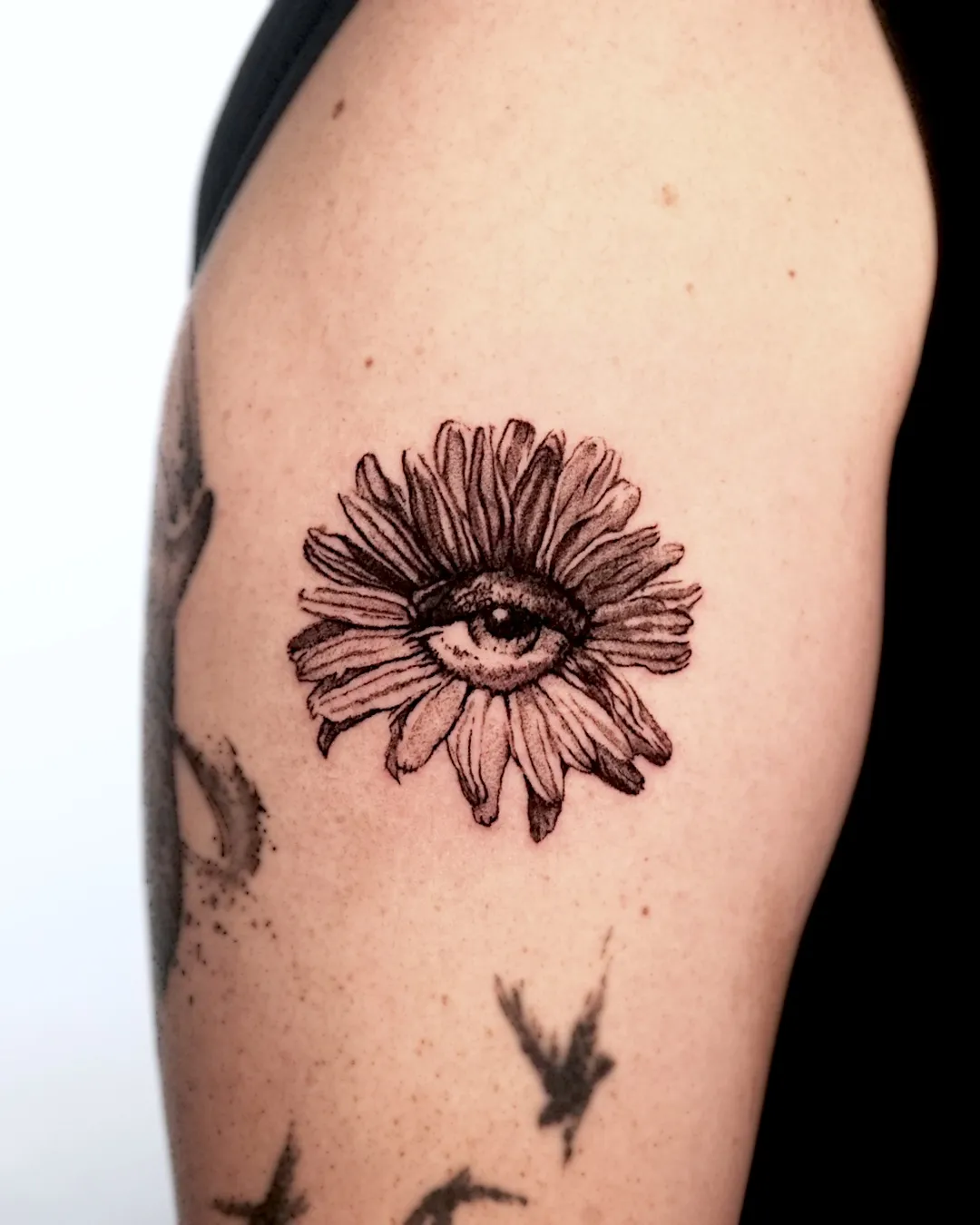 Wider view of the daisy-eye tattoo