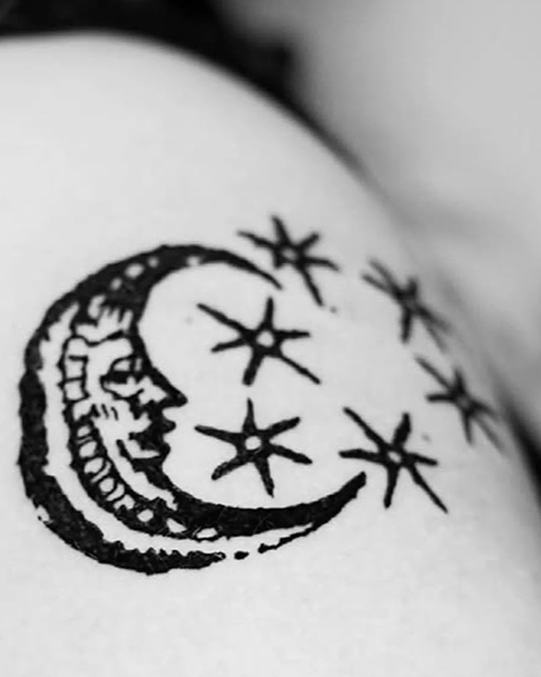 Woodcut style crescent moon with a face surrounded by stars